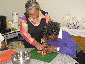 CAFB.ER.111809.Jackie helping participant chop tomato_reduc