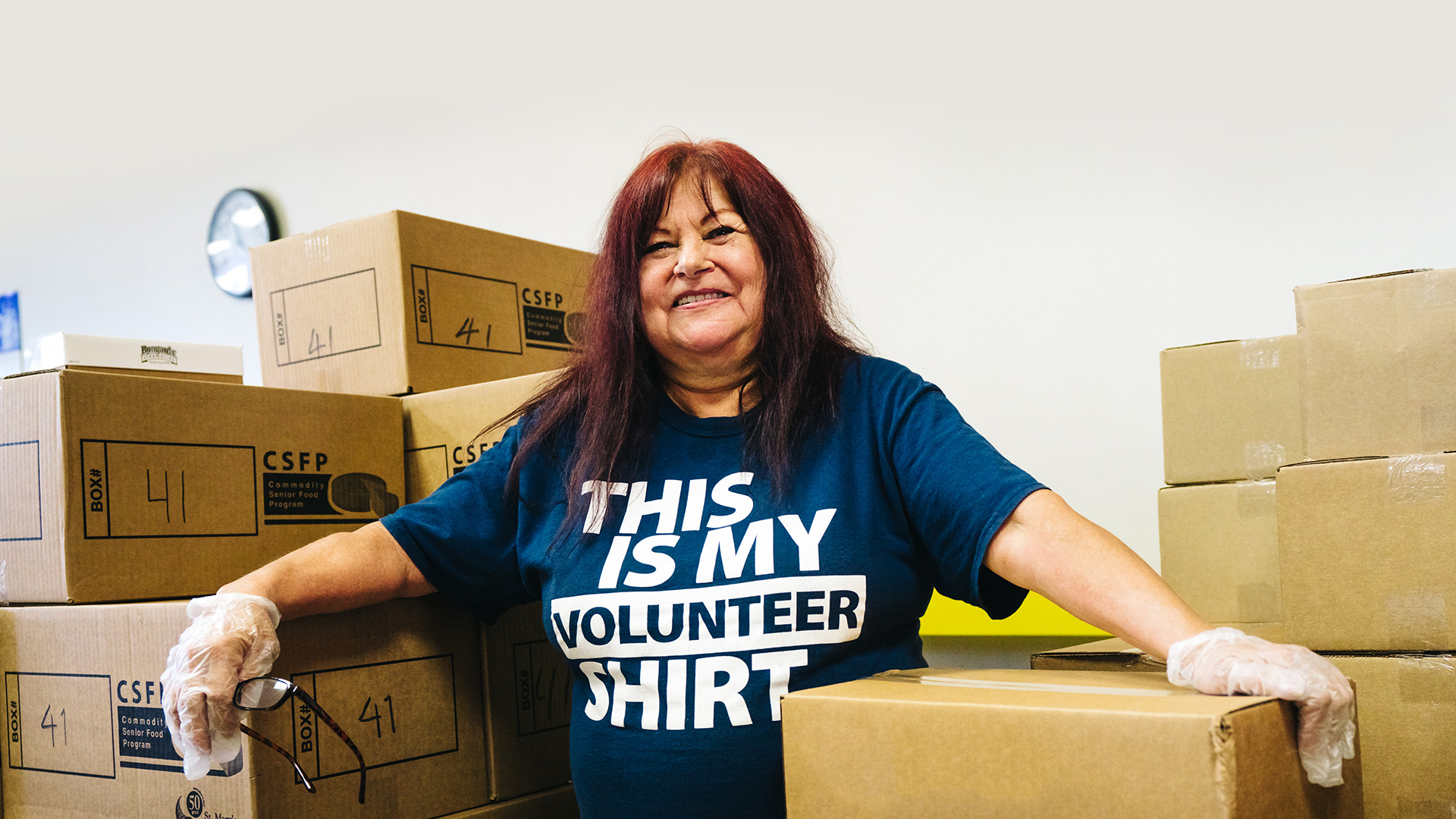 Volunteer helping sort donation boxes of food.